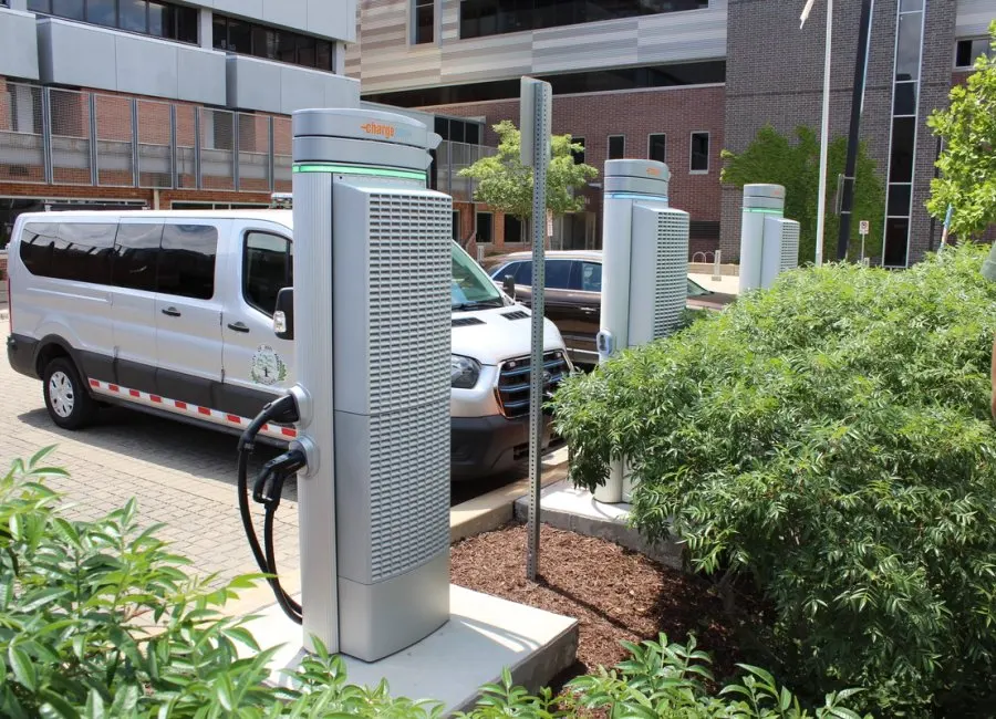 a person charges their electric vehicle at a charging station