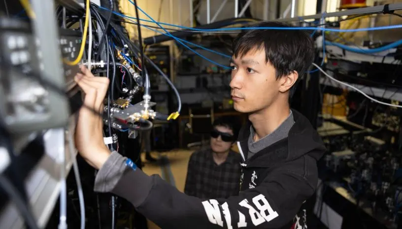 A person looking at wiring on some equipment