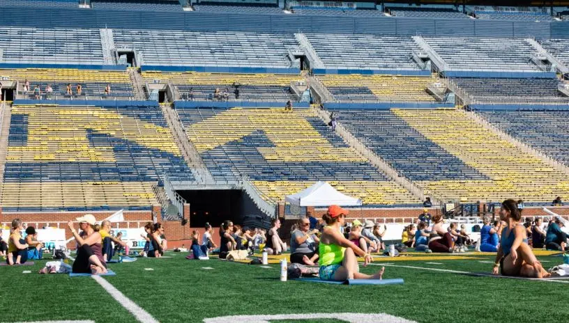 People doing yoga on the field in the Big House