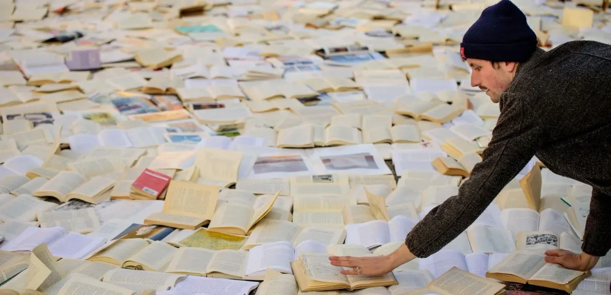 A person placing a book on Liberty Street for the “Literature vs. Traffic” exhibition where 10,000 books were placed on the street