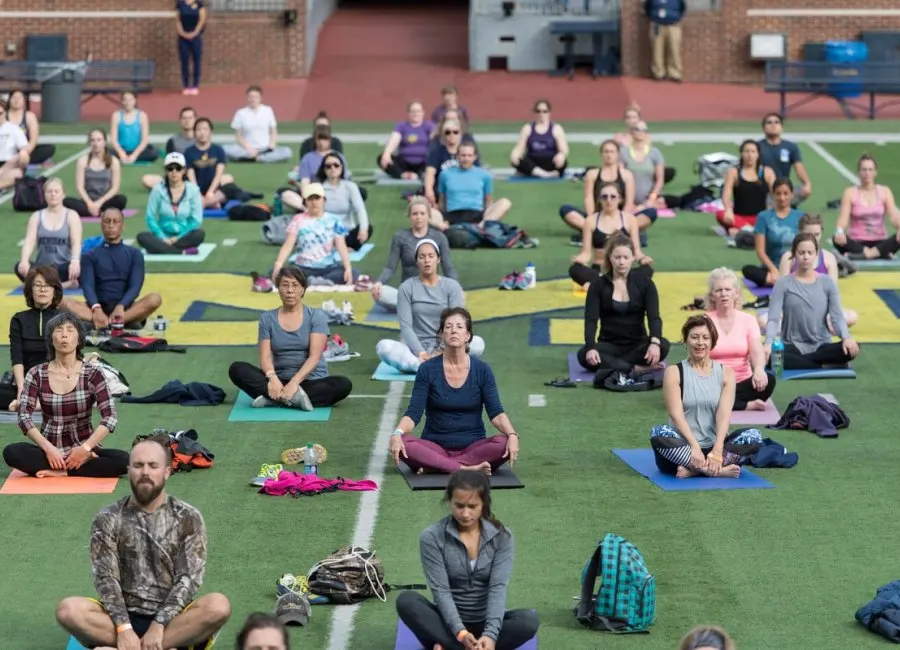 People doing yoga on the Big House field