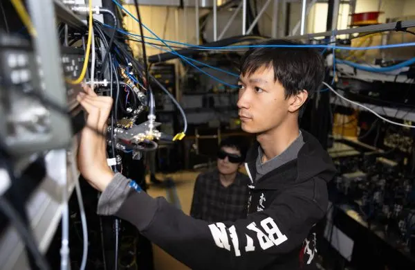 A person examining wiring on some equipment