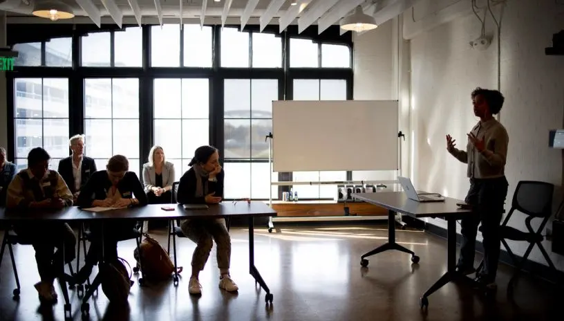 A lecture in a room with a large window
