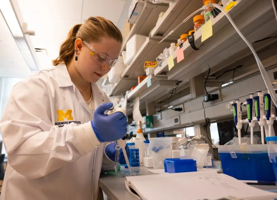 a female scientist uses a pipette
