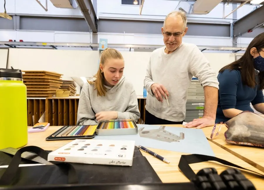 Professor teaches student in drawing class